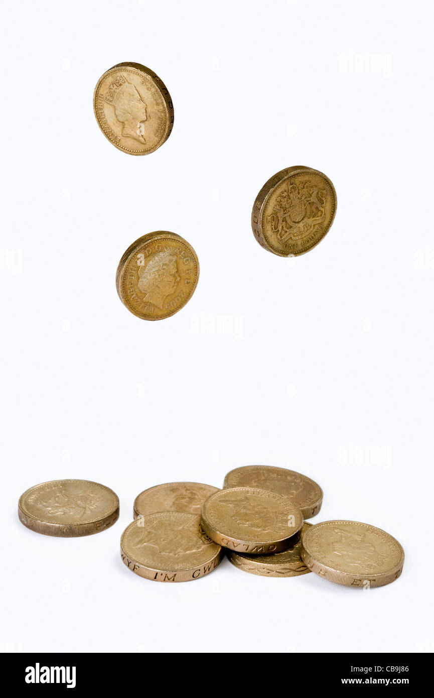 Una piccola pila di british una libbra di monete isolato su uno sfondo bianco con la caduta della sterlina monete Foto Stock