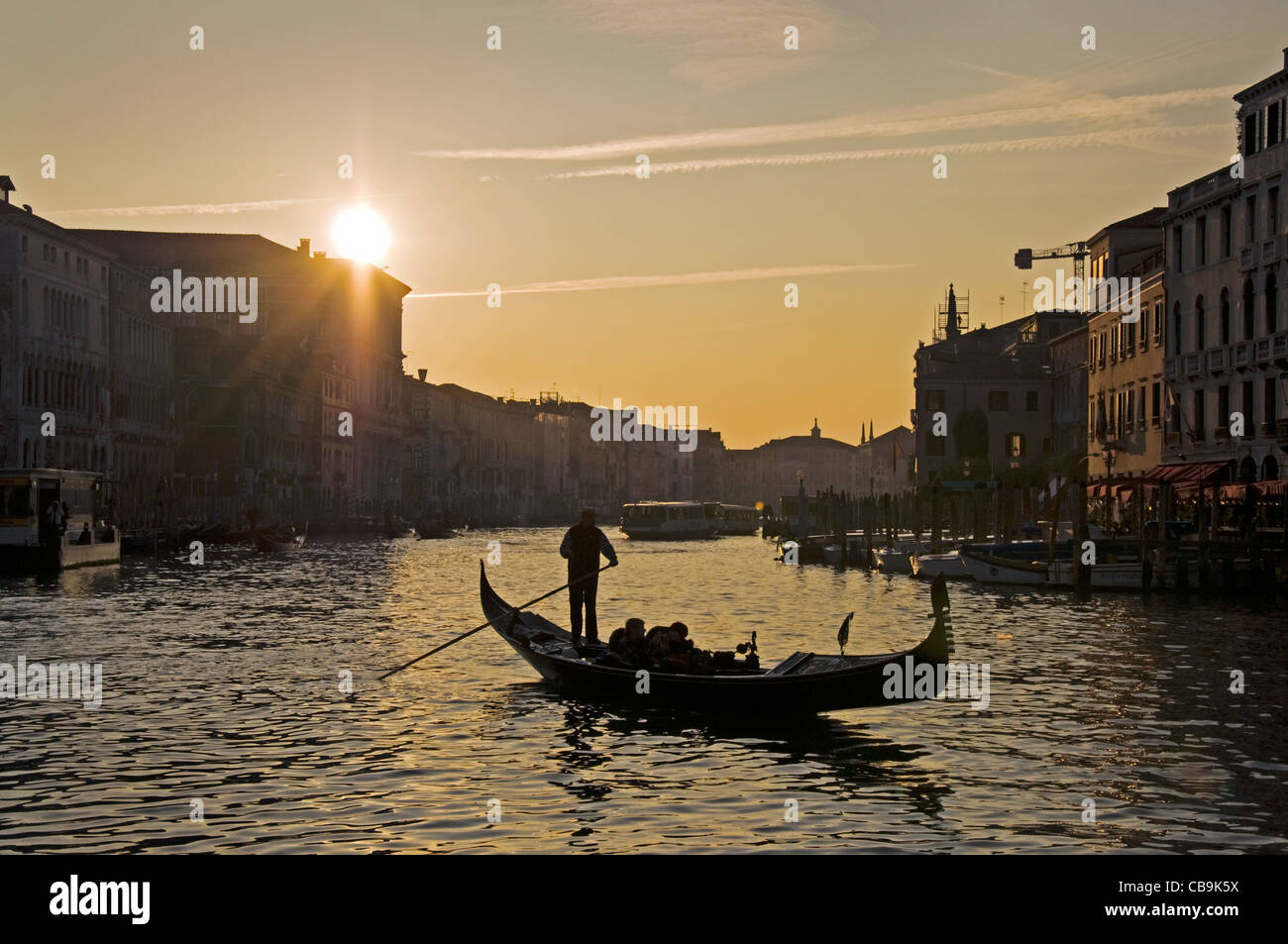 Silhouette di un gondoliere e gondola sul Canal Grande al tramonto Foto Stock