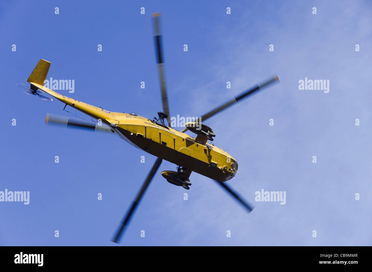 North Wales UK RAF Sea King HAR3una ricerca e salvataggio in elicottero volando in un cielo blu da sotto Foto Stock