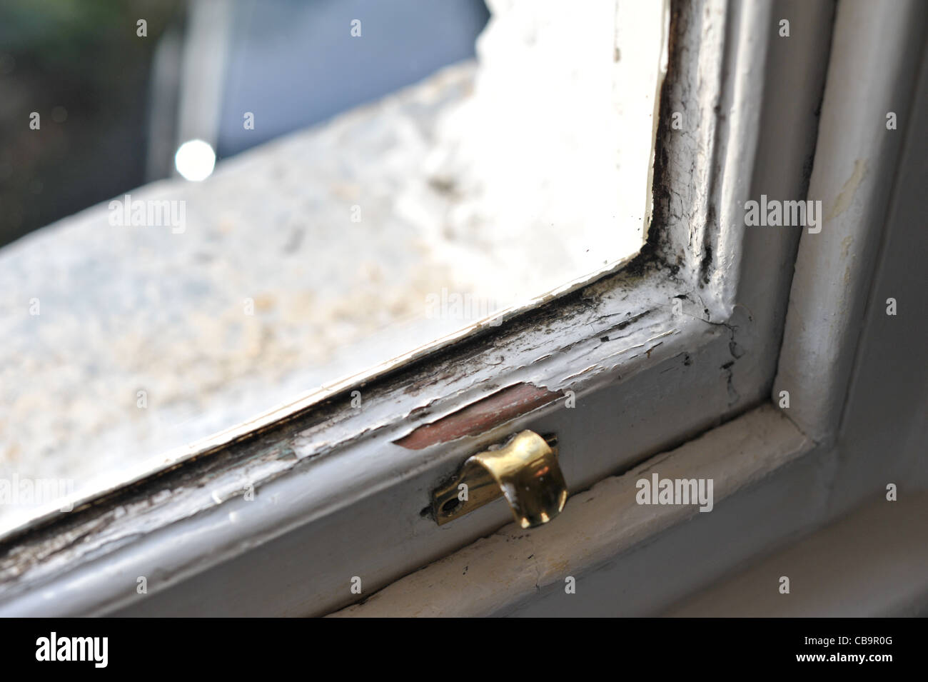 Legno marcio anta window danneggiata dalla presenza di umidità e condensa che necessitano di levigatura dell e riverniciatura per la riparazione Foto Stock