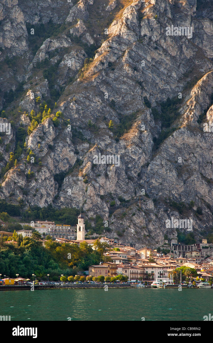 Imponente montagna si erge al di sopra di Limone-sul-Garda lungo le rive del Lago di Garda Lombardia Italia Foto Stock