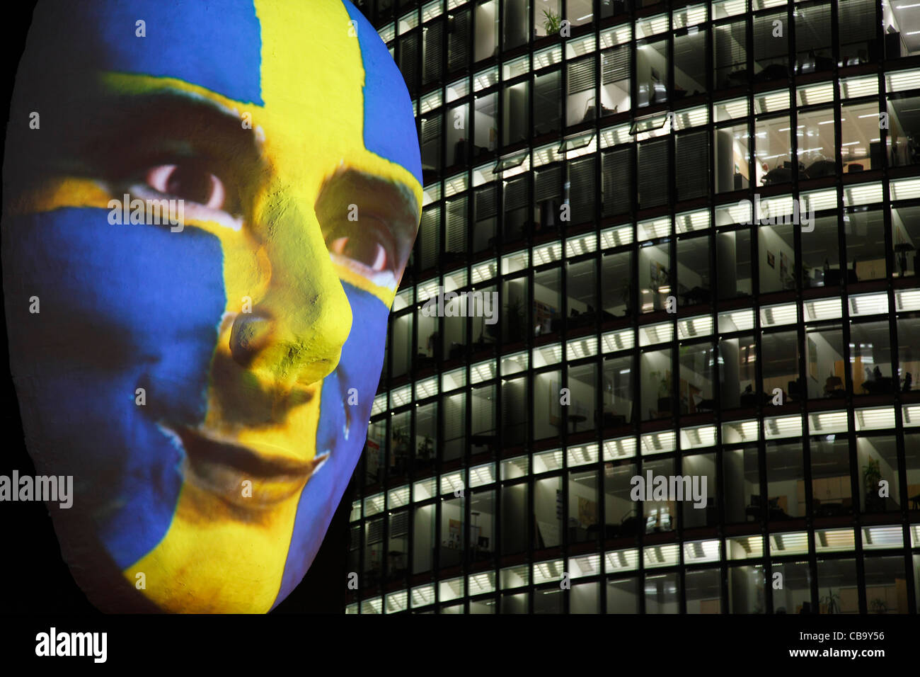 Enorme scultura di un viso illuminato da un'immagine di una bandiera svedese faccia dipinta durante la festa delle luci 2011 a Berlino Foto Stock
