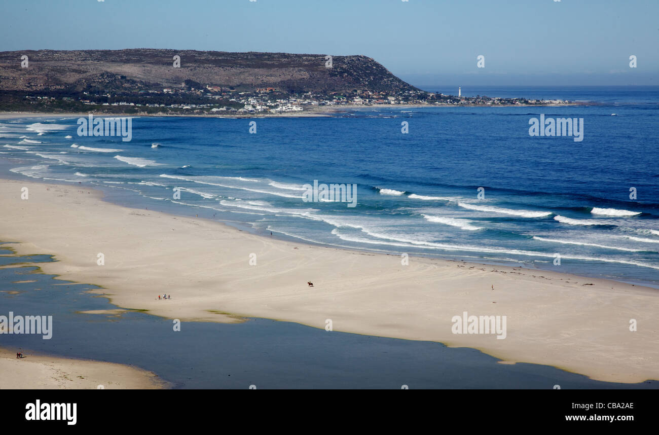 La distesa di spiaggia lunga, con Kommetjie in background, Penisola del Capo, in Sud Africa. Foto Stock