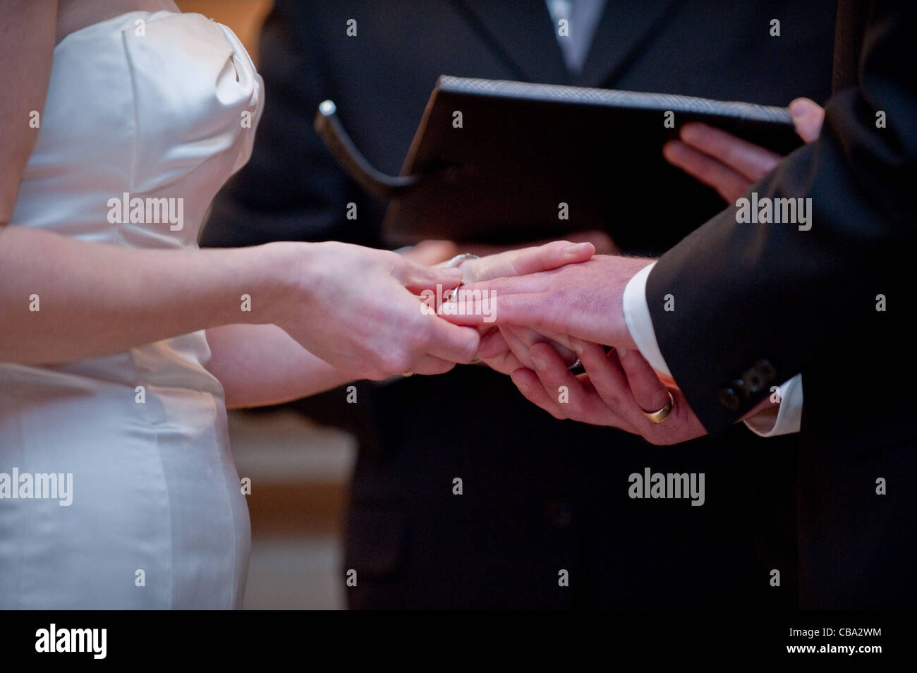 Un paio di scambi di nozze anelli mentre una lettura ufficiale voto script Foto Stock