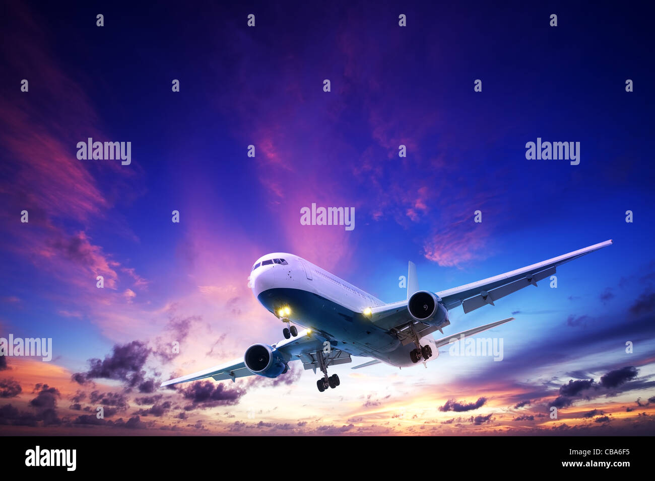 Gli aeromobili jet crociera in un Cielo di tramonto Foto Stock