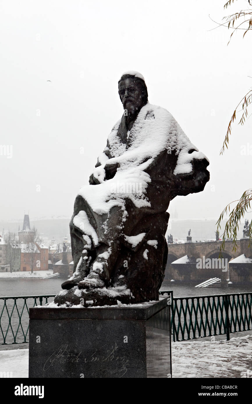 Praga, coperta di neve statua del compositore ceco Bedřich Smetana, con il fiume Moldava e sul castello di Praga in background. (CTK Foto Stock