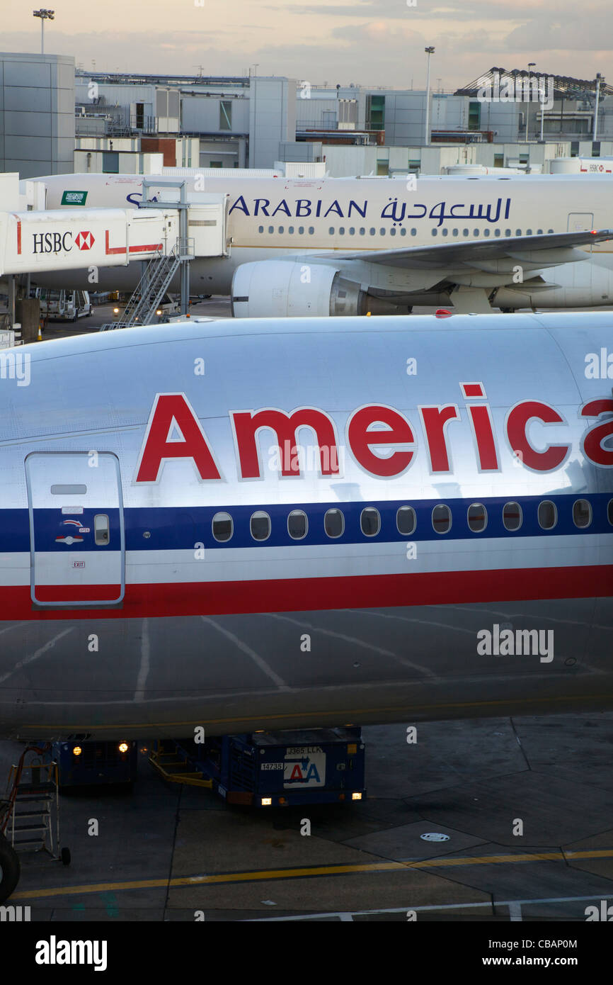 Americani e Arabian Airlines aeromobili parcheggiati in stand all'aeroporto di Heathrow di Londra, Regno Unito, Regno Unito, GB Gran Bretagna, Brit Foto Stock