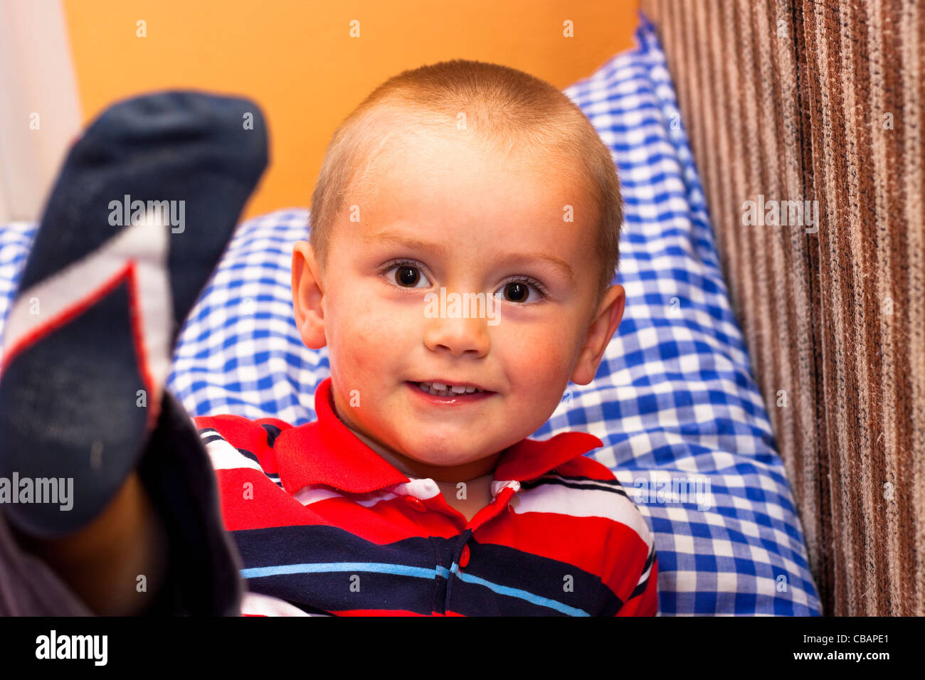 Ritratto di sorridenti little boy divertirsi sul letto. Foto Stock
