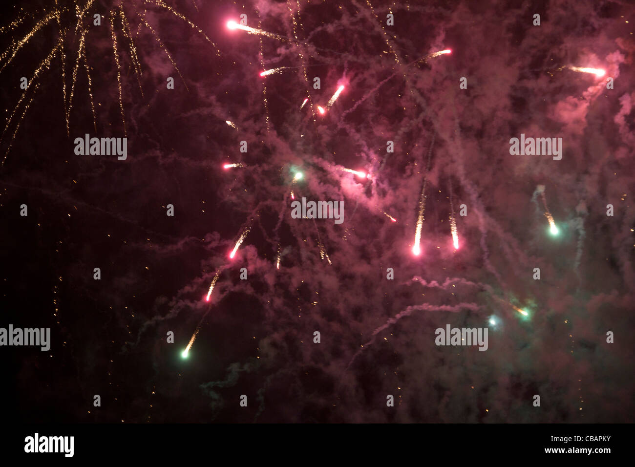 I fuochi d'artificio in Londra. Luci rosse shoot off in diverse direzioni creando una nuvola di polvere riempiendo il cielo di notte. Foto Stock