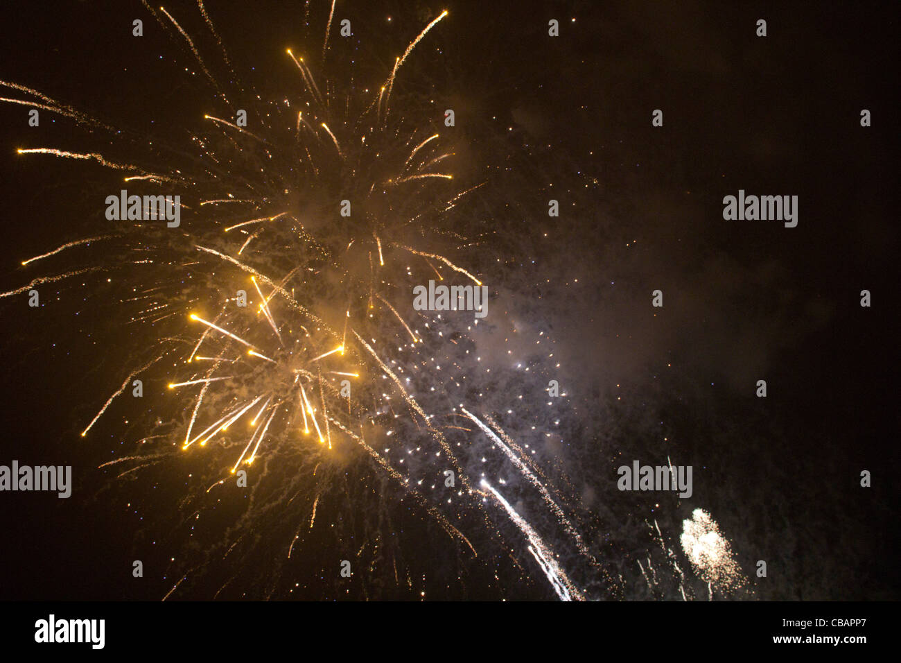 Enorme golden fuochi d'artificio che esplodono nel cielo notturno come la nube di polvere si deposita. Londra Foto Stock