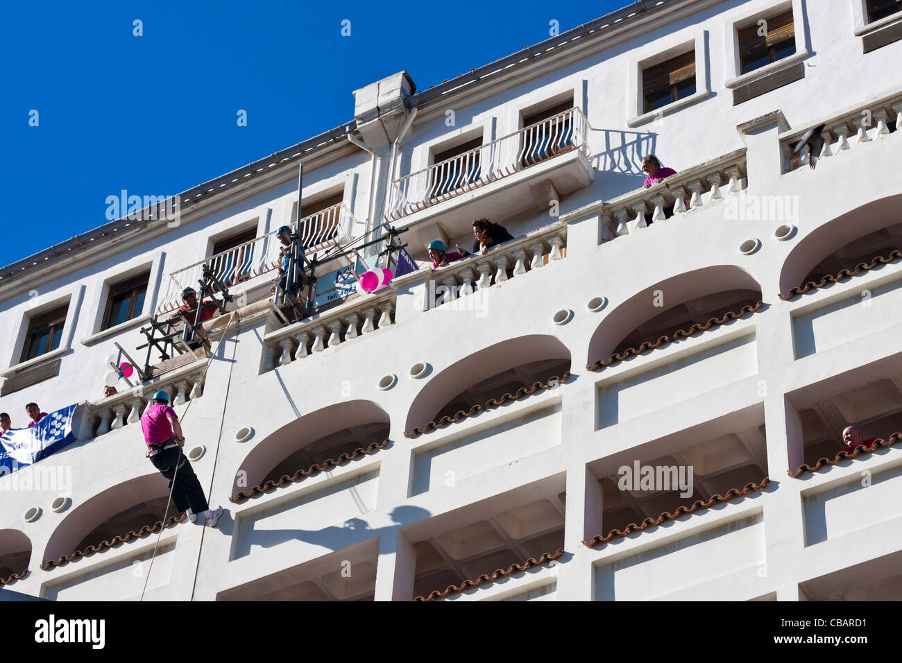 Un uomo rappels un edificio per carità, Main Street, Gibilterra. Foto Stock