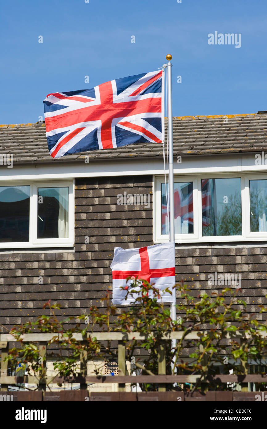 Union Jack, bandiera britannica e St George's Cross, Inghilterra bandiera contro una casa residenziale, Southampton, Hampshire, Inghilterra, Regno Unito Foto Stock