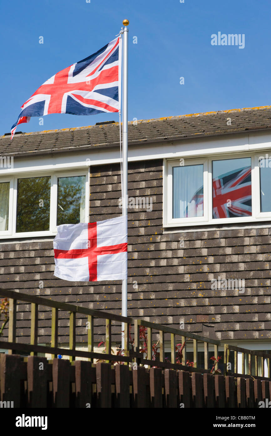 Union Jack, bandiera britannica e St George's Cross, Inghilterra bandiera contro una casa residenziale, Southampton, Hampshire, Inghilterra, Regno Unito Foto Stock