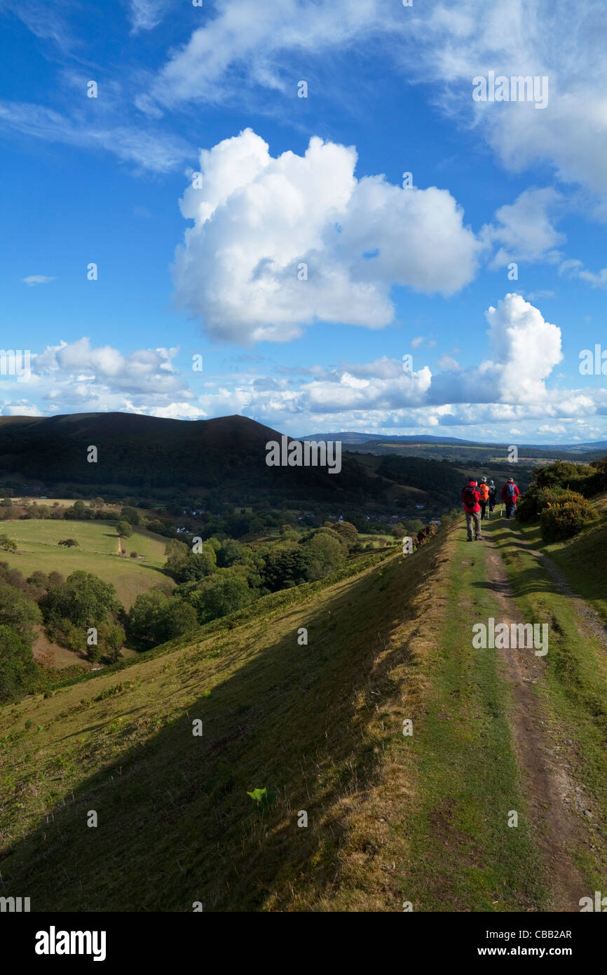 Gli escursionisti sulla via lungo il fianco della montagna callow, sopra poco stretton, Shropshire, Inghilterra, Regno Unito Foto Stock