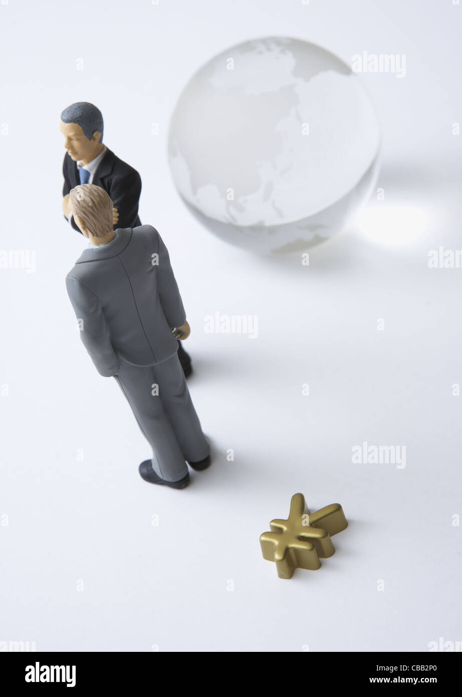 Globo di vetro, gli imprenditori in miniatura, e segno di yen Foto Stock