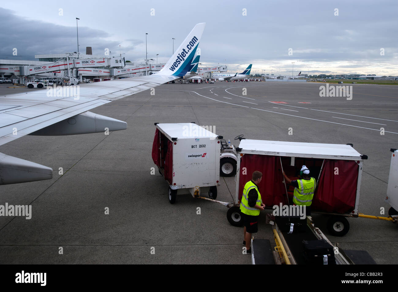 Bagagli fuori su asfalto lo scarico di un aereo in un aeroporto Foto Stock