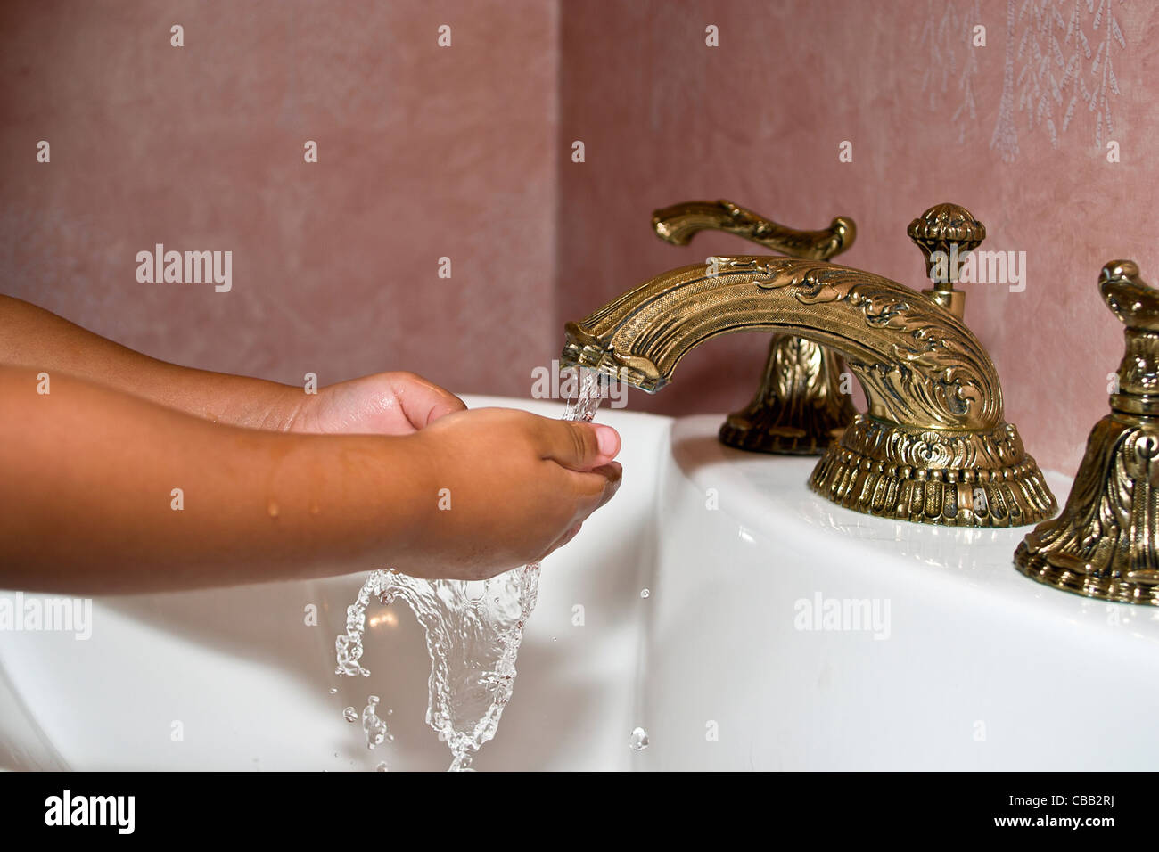 Ragazzo ispanico lavarsi le mani nel lavandino con acqua corrente. Signor © Myrleen Pearson Foto Stock
