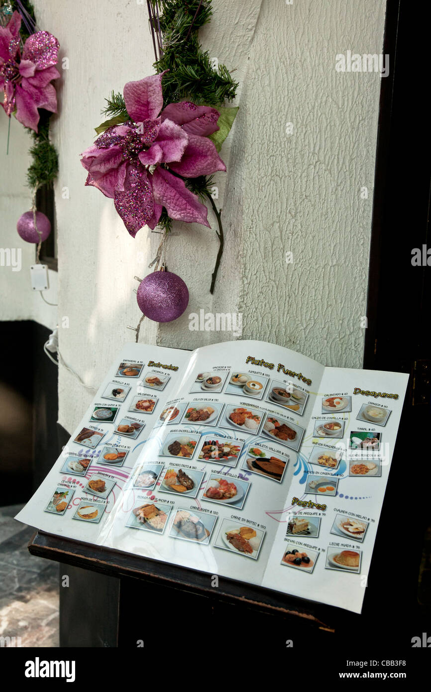 Il menu illustrato visualizzata all'esterno di ingresso al ristorante con decorazioni di Natale su intonaco grezzo parete sopra il quartiere di Roma Foto Stock