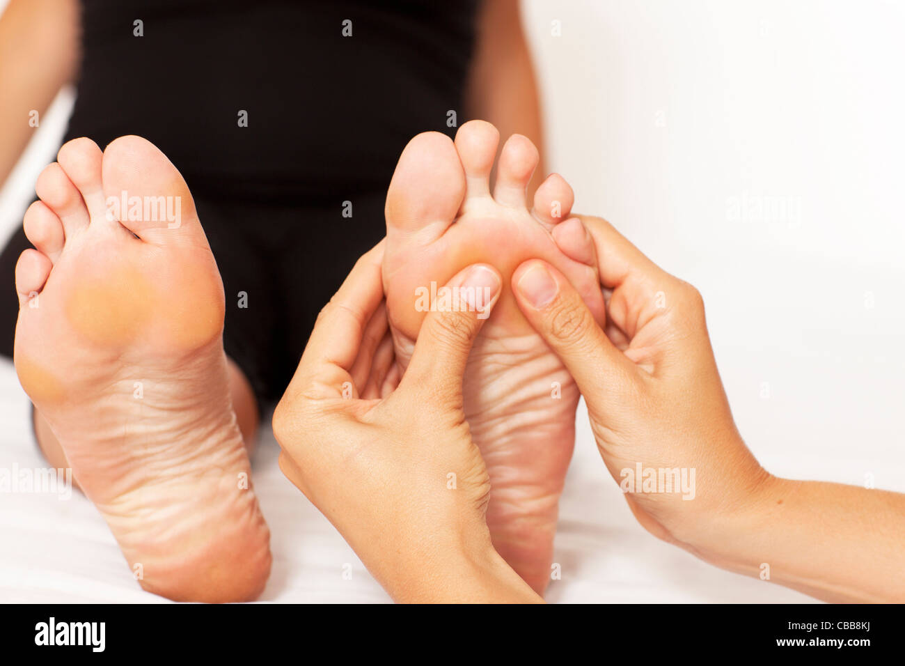 Le mani umane massaggiare una donna di piedi Foto Stock
