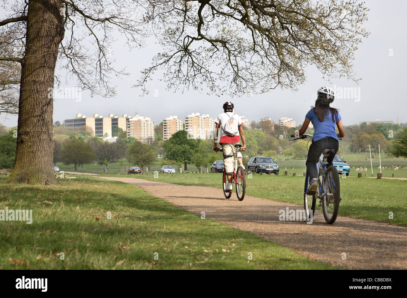 I ciclisti in Richmond Park, a sud-ovest di Londra, che mostra l'appartamento bocks di Roehampton in background Foto Stock