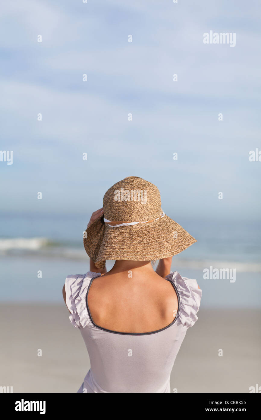 Donna che indossa cappello di paglia sulla spiaggia Foto stock - Alamy