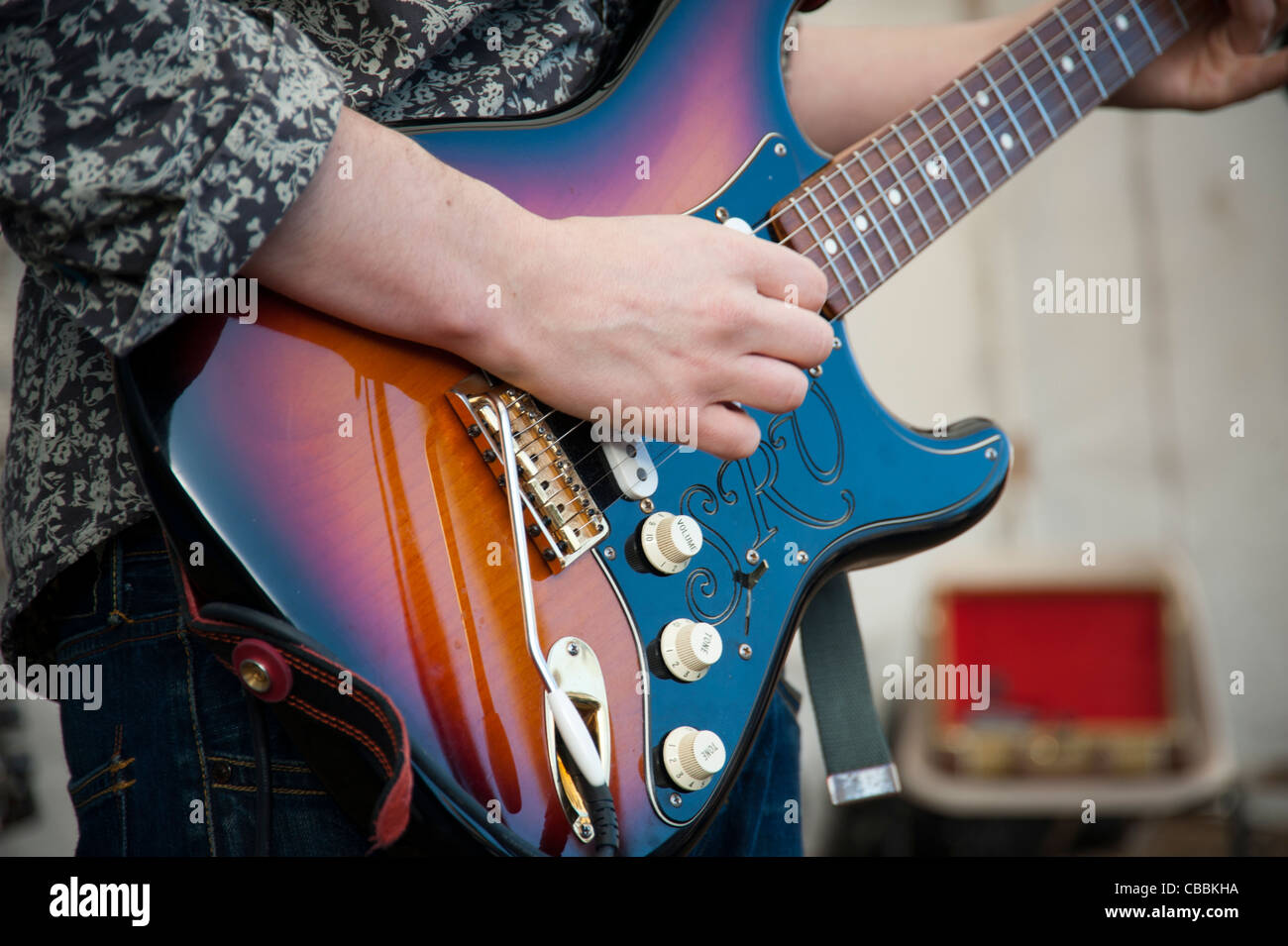 L'uomo gioca Fender Stratocaster SRV chitarra, chiudere in mostra le mani e corpo della chitarra. Foto Stock