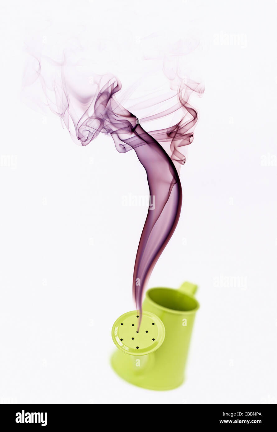 Il fumo versando del mini annaffiatoio che assomiglia a una lampada genie Foto Stock