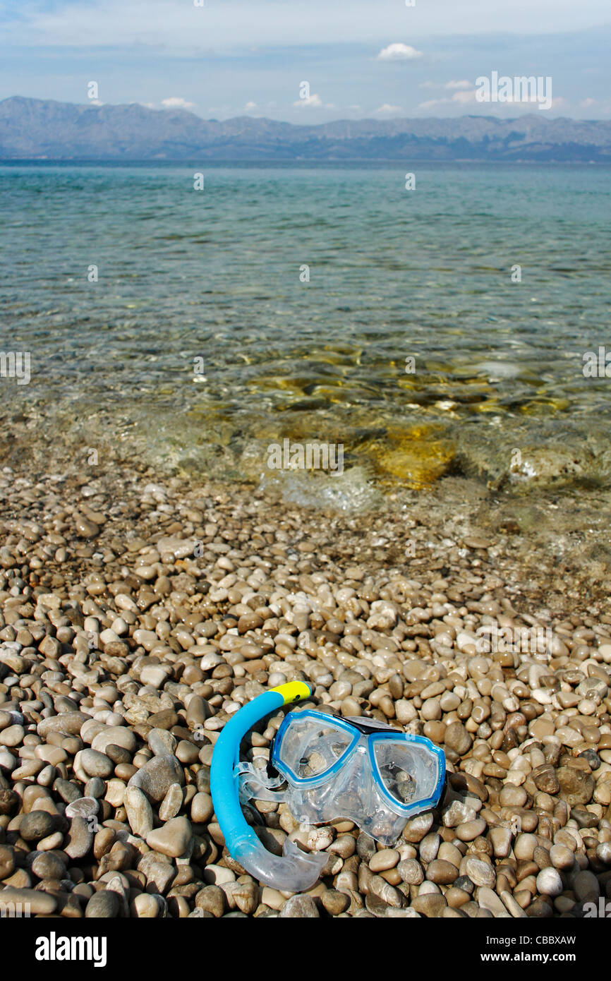 Maschera subacquea che giace sulla spiaggia di ciottoli, Croazia Foto Stock