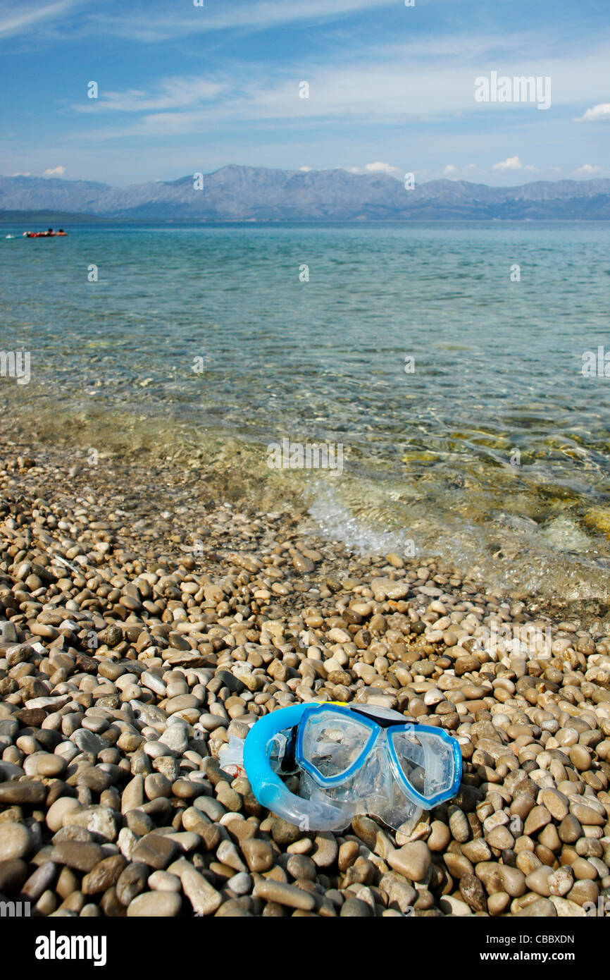 Maschera subacquea che giace sulla spiaggia di ciottoli, Croazia Foto Stock