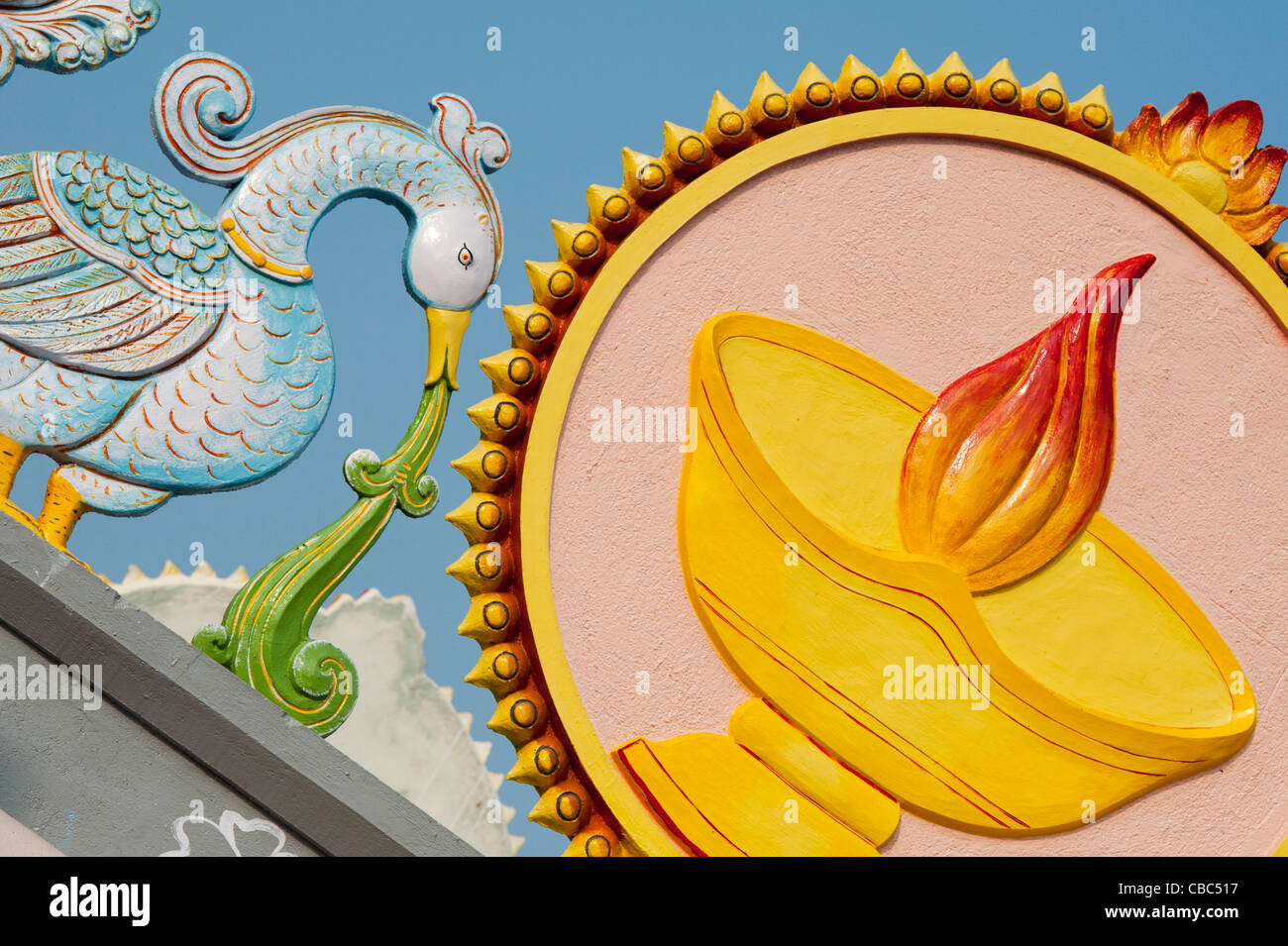 Tempio indiano scultura raffigurante gli uccelli che circonda una lampada e la fiamma. Puttaparthi, Andhra Pradesh, India Foto Stock