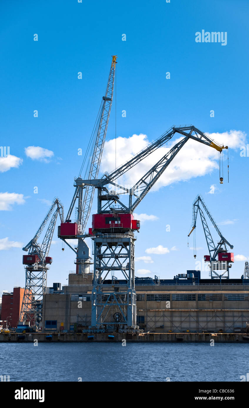 Porto di mare le gru con blu cielo nuvoloso in background e acqua in primo piano nel porto di Helsinki, Finlandia Foto Stock