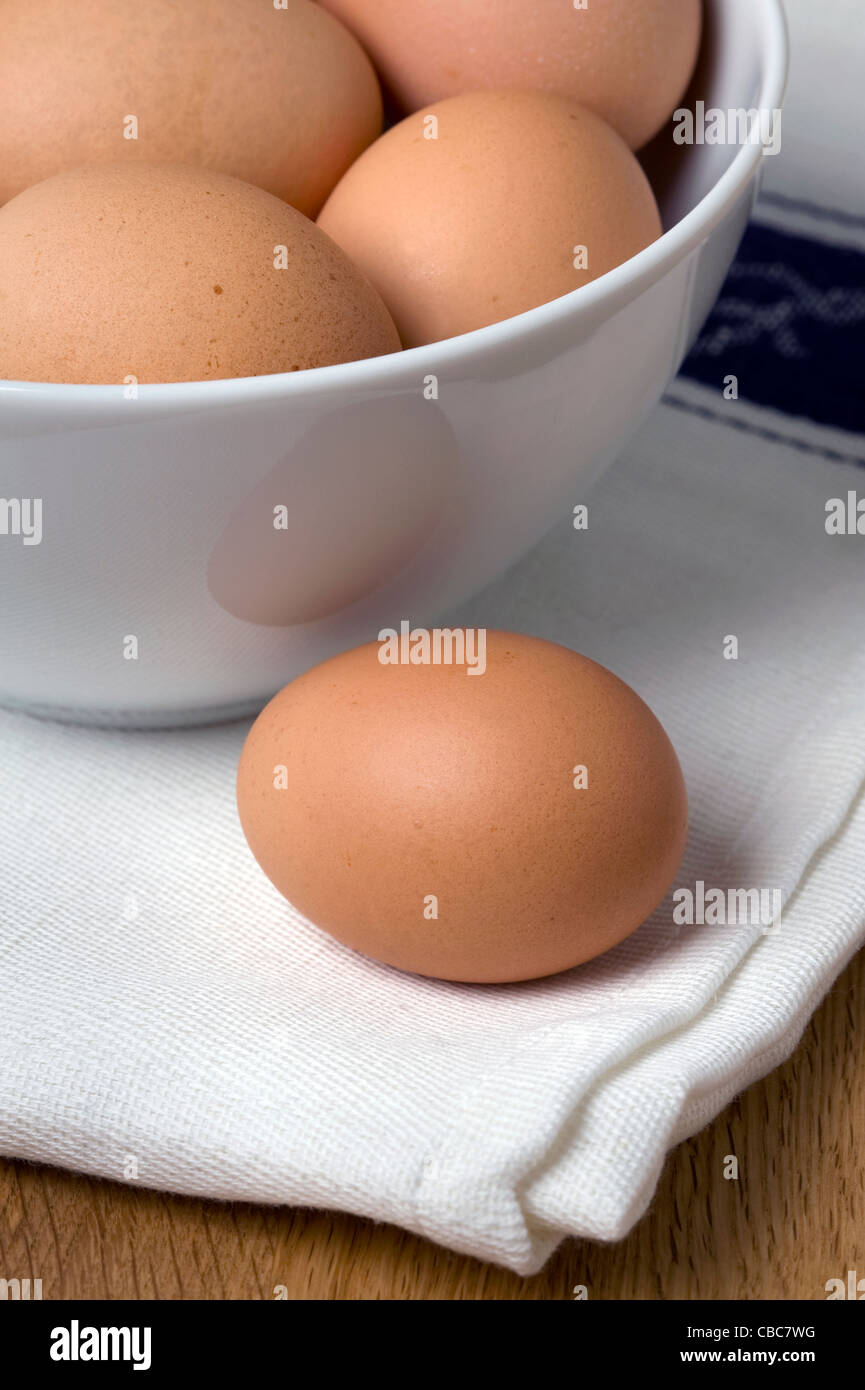 Brown uova di galline in un bianco vaso in ceramica su un lino canovaccio Foto Stock