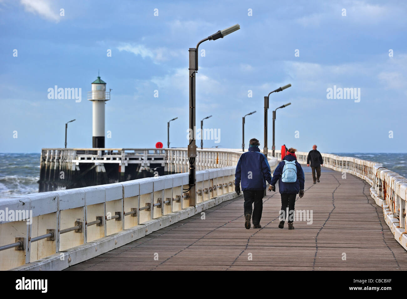 I turisti camminando sul molo di legno durante le tempeste, Nieuwpoort, Belgio Foto Stock