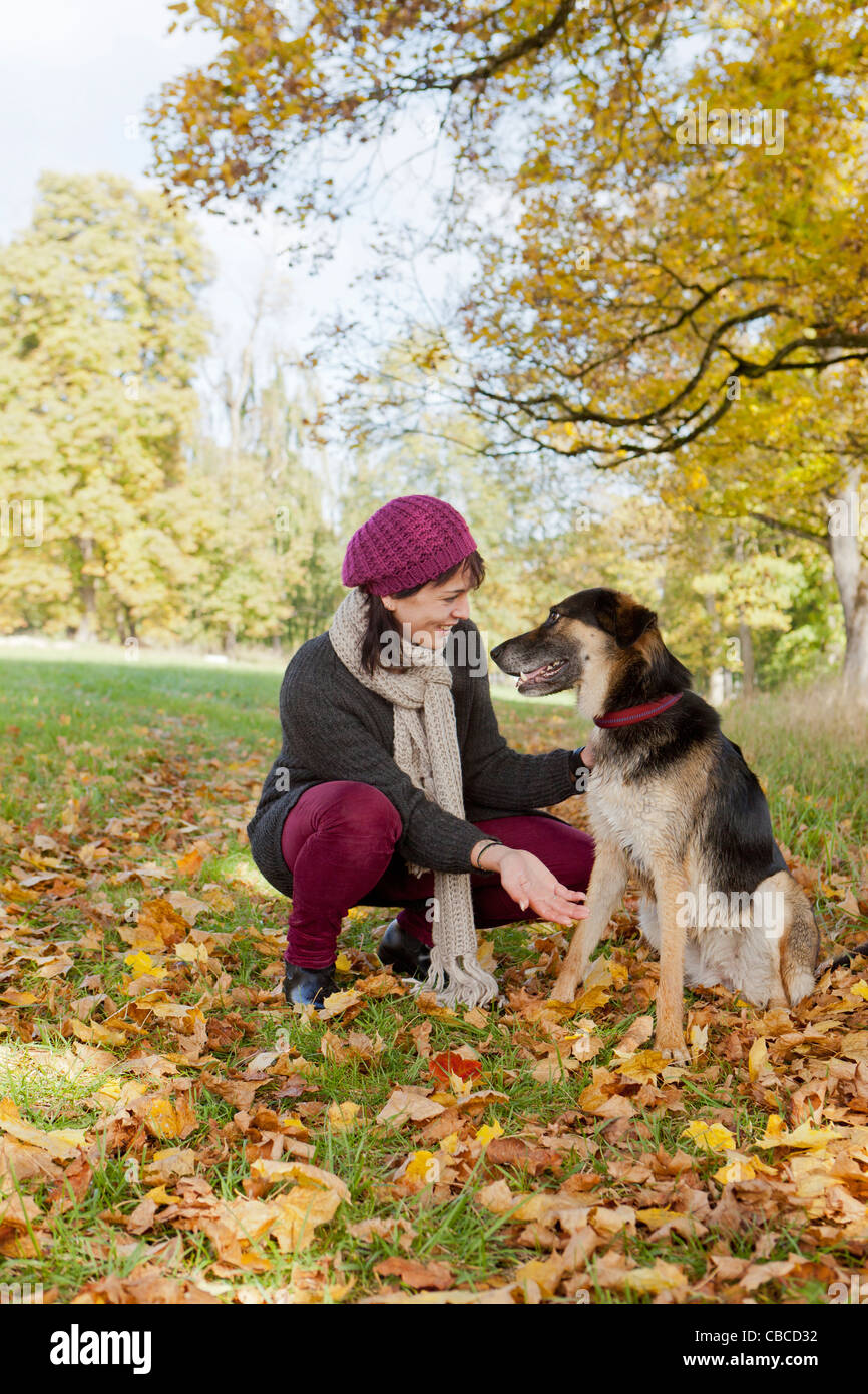 Donna sorridente petting cane in posizione di parcheggio Foto Stock Donna sorridente petting cane in posizione di parcheggio Foto Stock