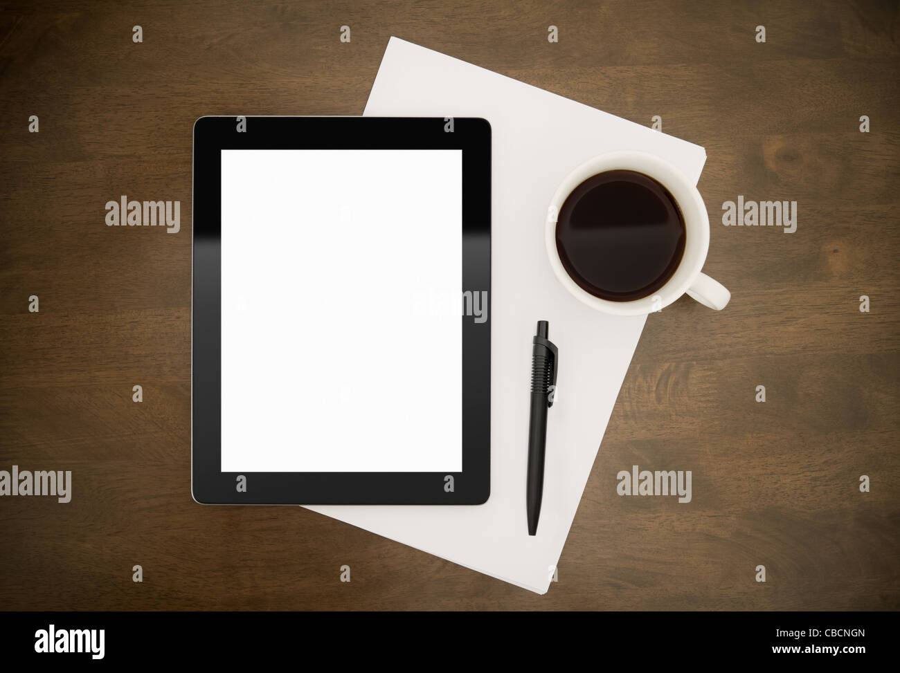 Contemporanea tavoletta digitale con schermo vuoto giacente sul piano di lavoro con carta e penna e la tazza di caffè. Top direttamente al di sopra di vista. Foto Stock