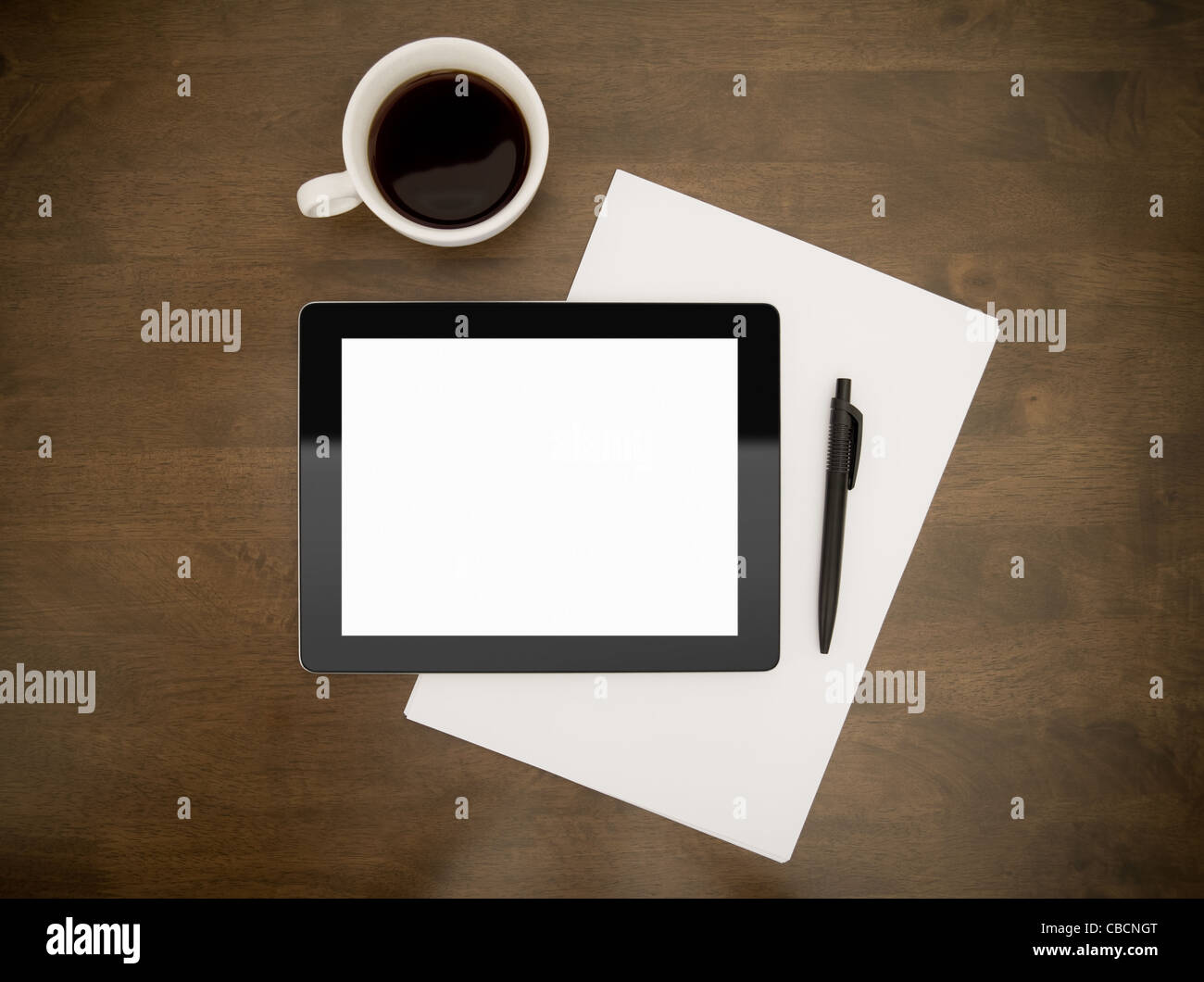 Contemporanea tavoletta digitale con schermo vuoto giacente sul piano di lavoro con carta e penna e la tazza di caffè. Top direttamente al di sopra di vista. Foto Stock