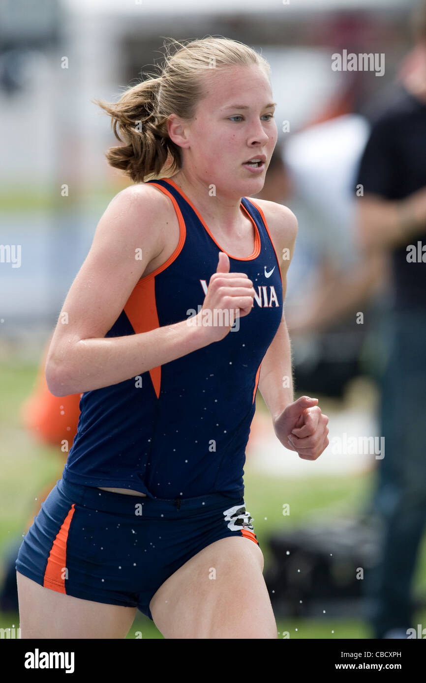 Una femmina di distanza runner durante una gara in un collegio via e il campo di soddisfare Foto Stock