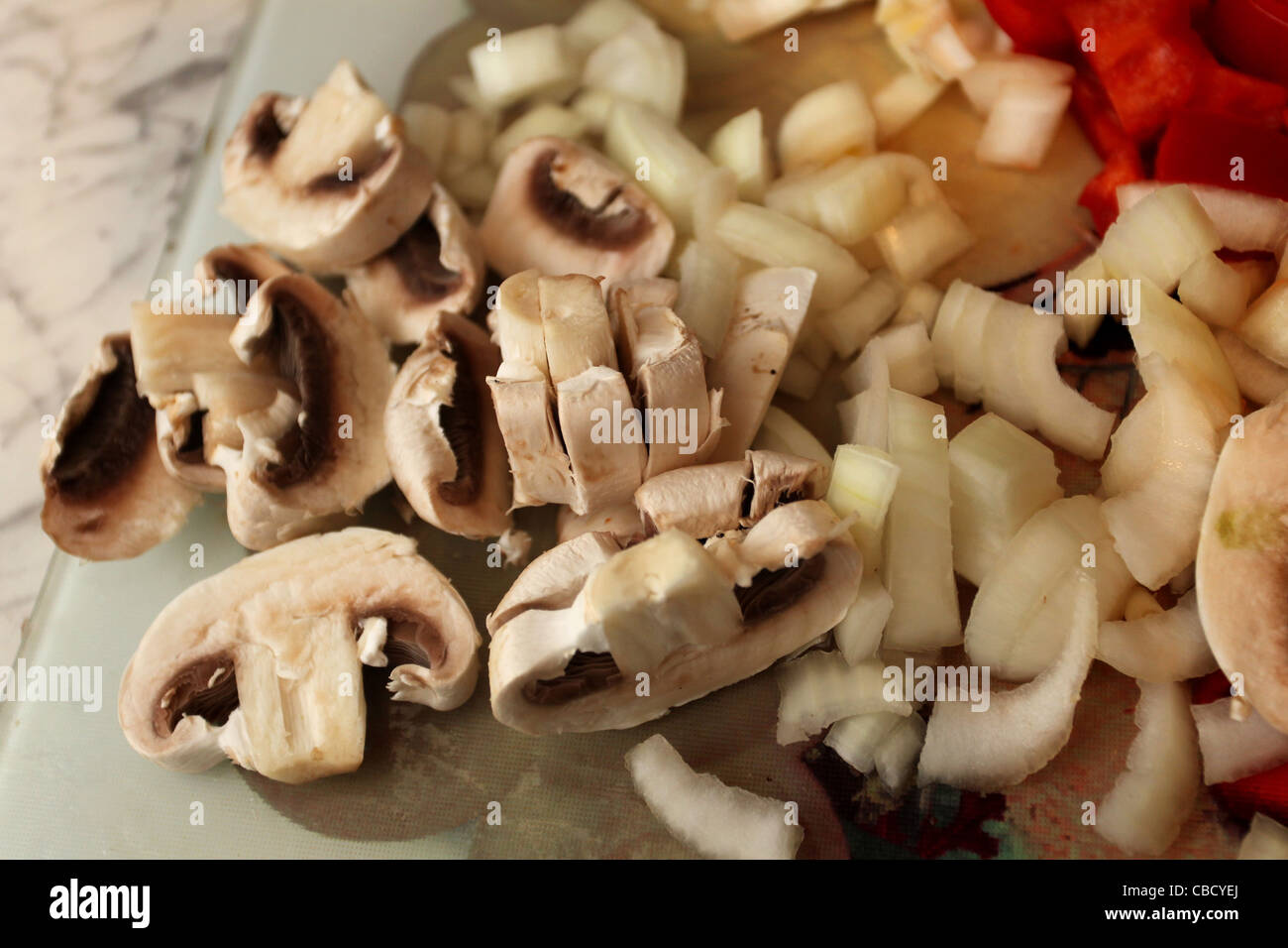 I funghi e le cipolle preparate per la cottura in una cucina a Hove, East Sussex, Regno Unito. Foto Stock