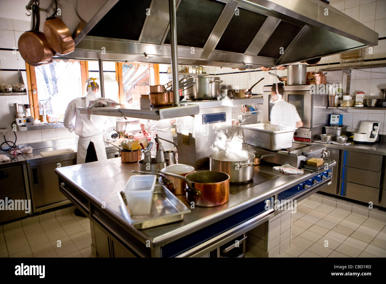 Chef operanti in cucina commerciale, pentola per la cottura sulla stufa Foto Stock