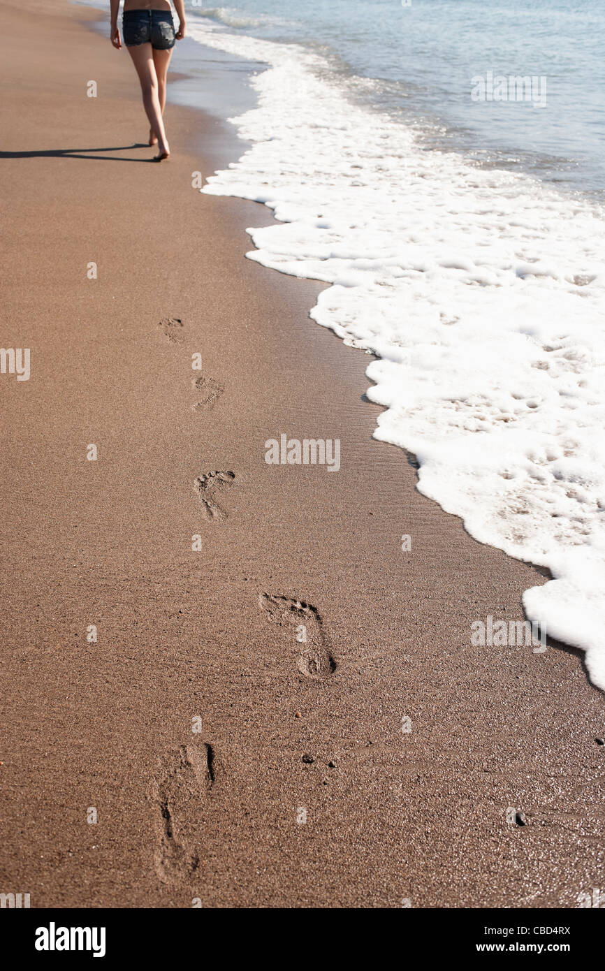 Donna di impronte sulla spiaggia Foto Stock