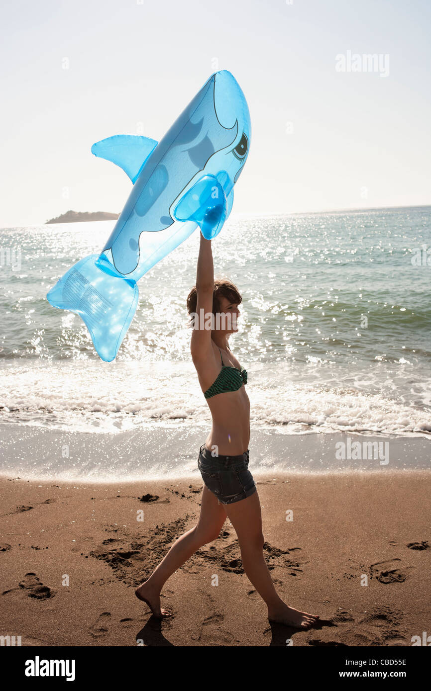 Donna con il giocattolo gonfiabile sulla spiaggia Foto Stock