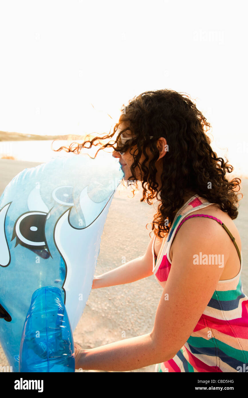 Donna baciare giocattolo gonfiabile sulla spiaggia Foto Stock