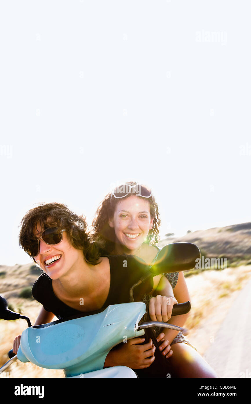 Sorridente donne equitazione scooter insieme Foto Stock