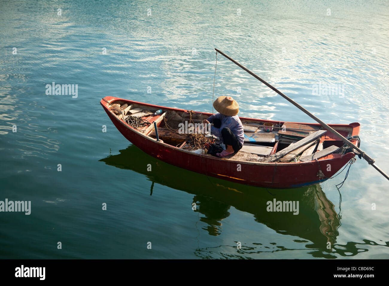 Vecchia donna in una tradizionale barca da pesca, Sau Mun Tsai Villaggio di Pescatori, Hong Kong, Cina Foto Stock