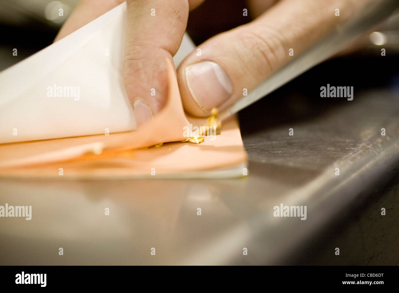 Lo chef prepara commestibili foglia oro Foto Stock