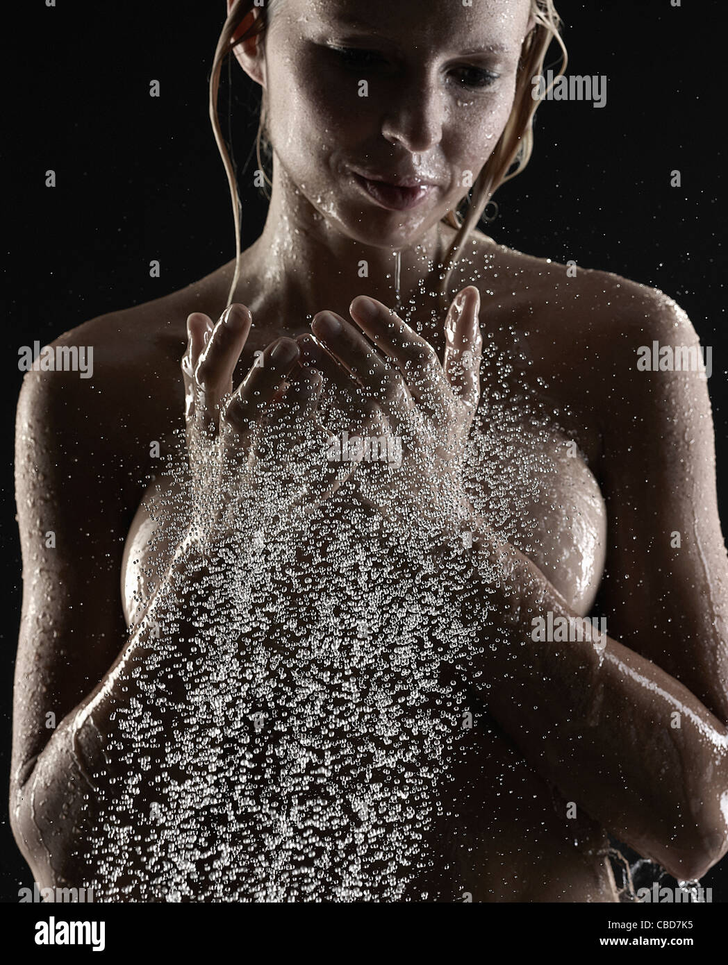 La donna gli spruzzi di acqua su se stessa Foto Stock