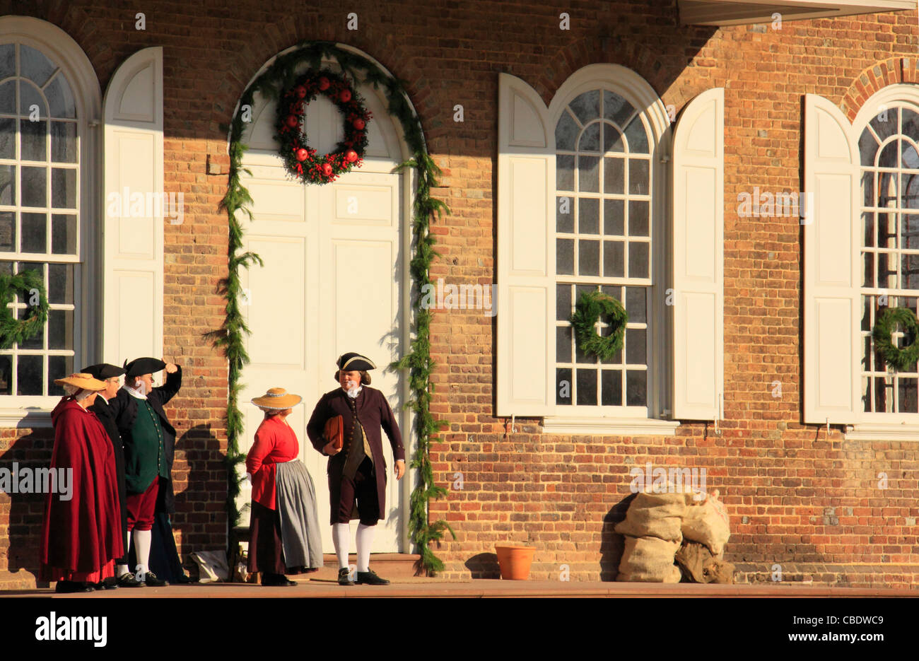 Gli uomini e le donne con le decorazioni di Natale di fronte Courthouse, Colonial Williamsburg, Virginia, Stati Uniti d'America Foto Stock