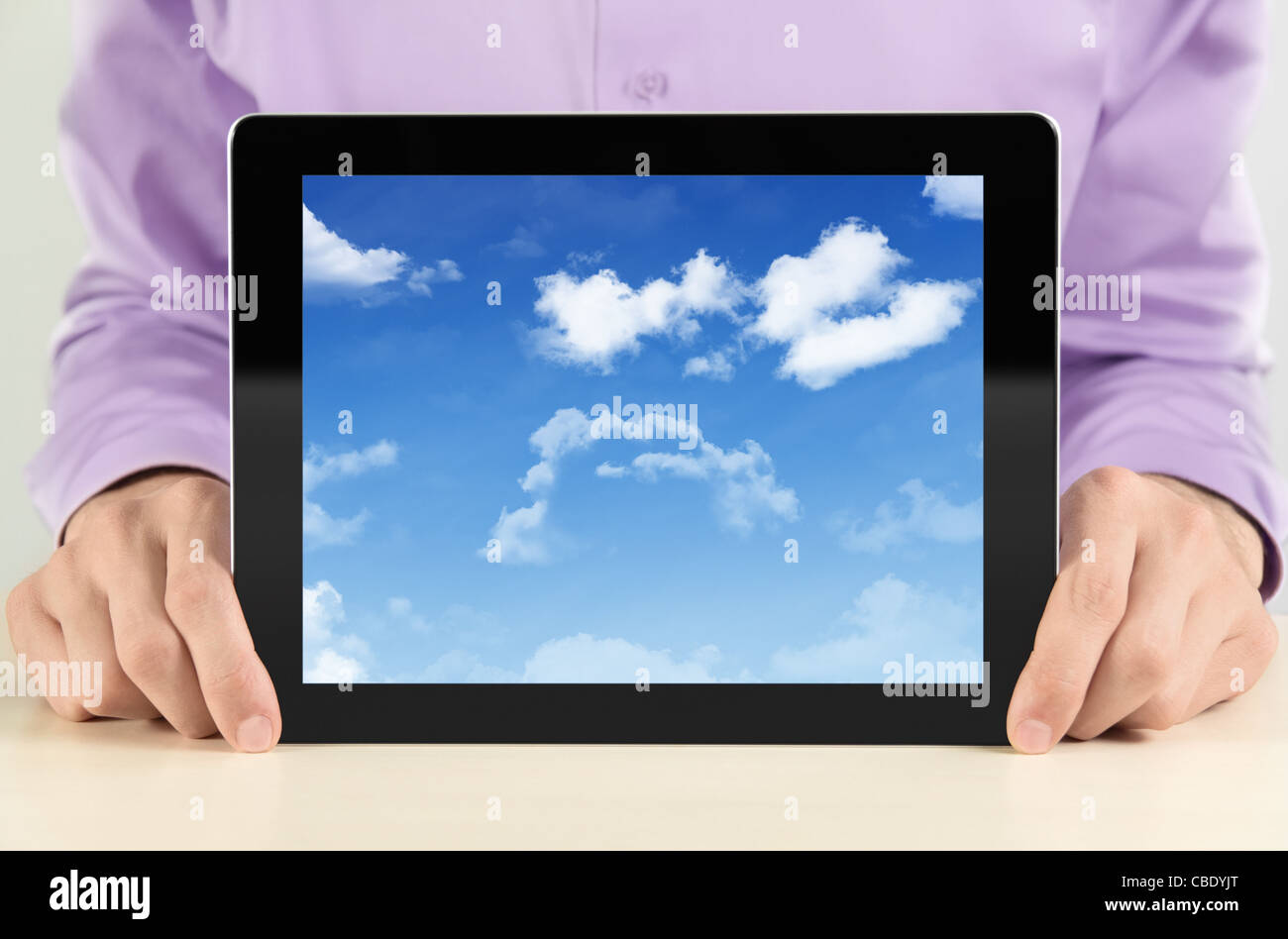 Imprenditore mostra digital tablet pc con cloudscape sullo schermo. Concetto di immagine su un cloud-computing tema. Foto Stock