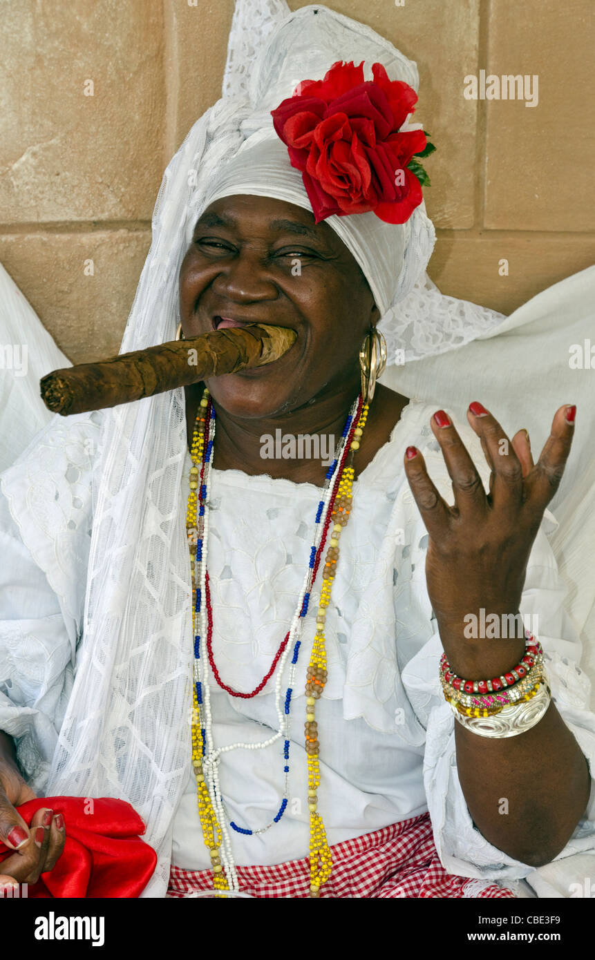 Donna cubana che indossa un Santeria abito bianco di fumare un sigaro di grandi dimensioni La Habana Vieja La Habana Cuba Foto Stock
