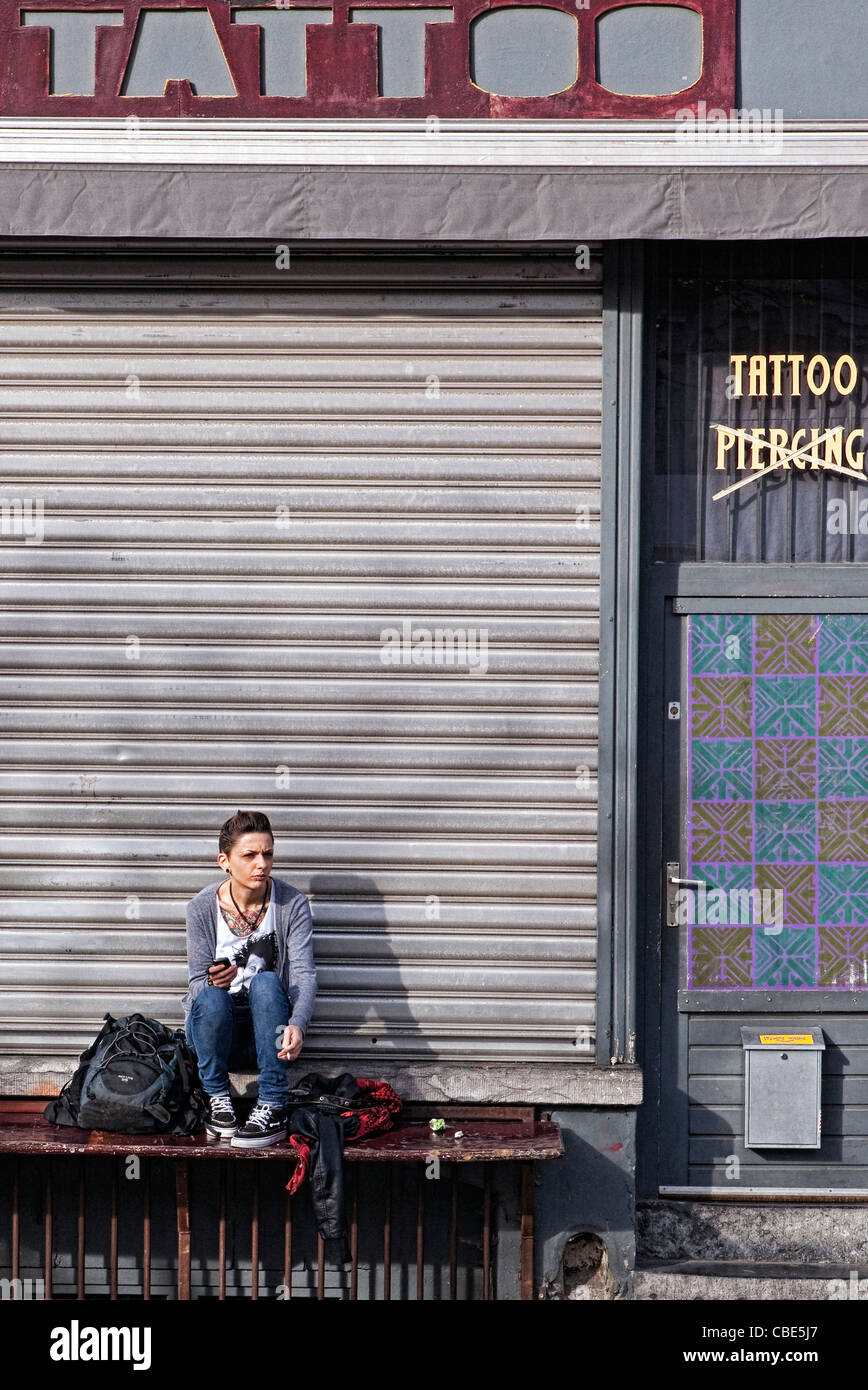 Giovane ragazza seduta davanti a un salotto tattoo Foto Stock